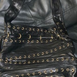 Kooba black leather bag with grommets.